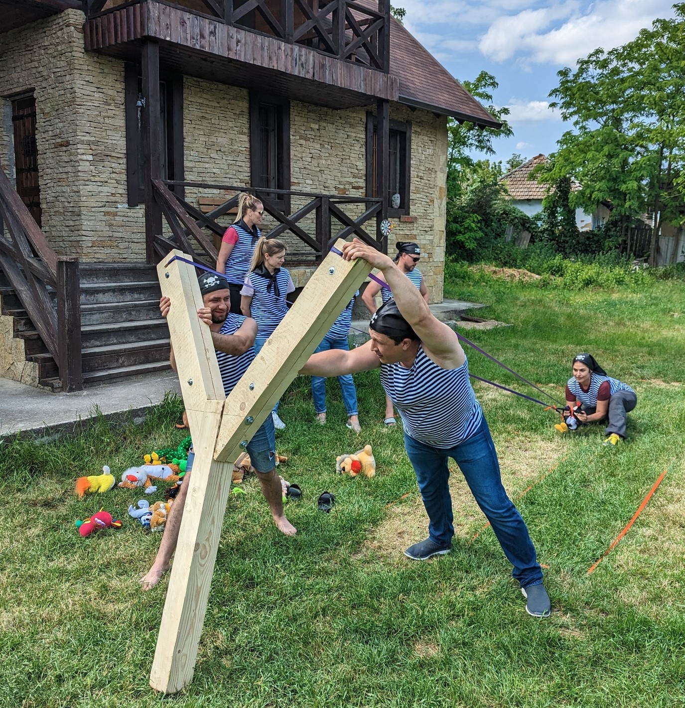 Echipă folosind o praștie uriașă pentru a lansa proiectile activitate de teambuilding creativă și competitivă