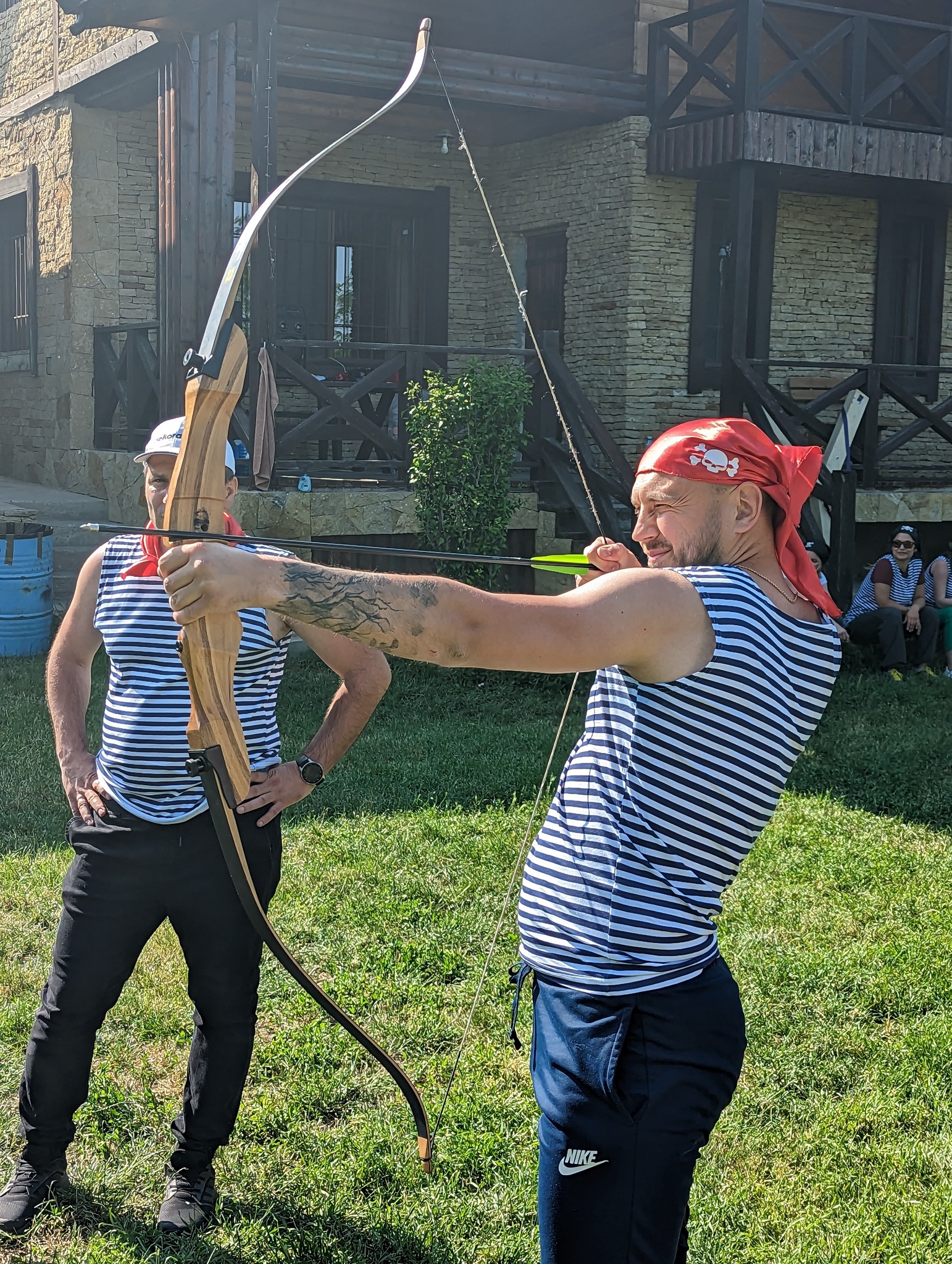 Angajat trăgând cu arcul într-o probă de teambuilding tip Ținta Căpitanului, dezvoltare a concentrării și coordonării